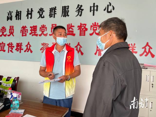 正在為群眾辦事的沈家江（左）。